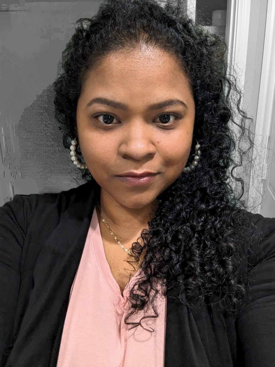 A Giving Care Houston caregiver smiles warmly, photographed in soft natural light.
